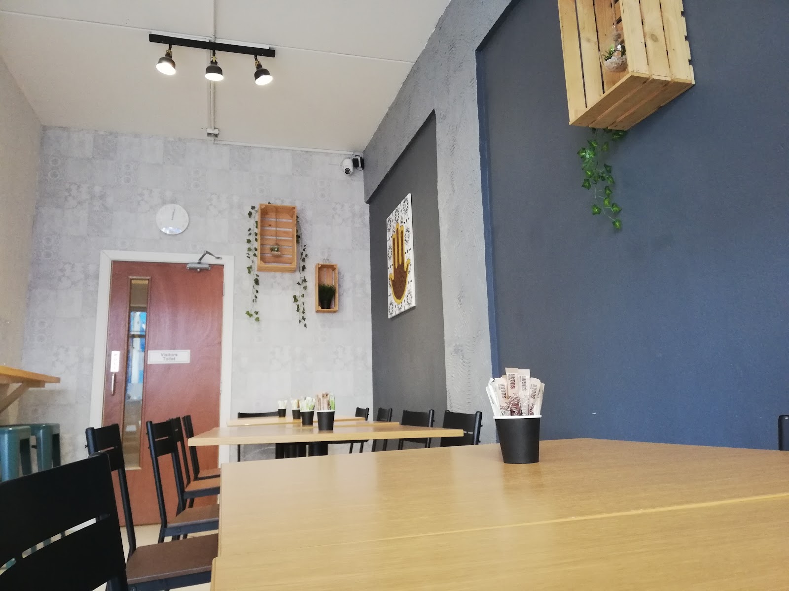Inside Ménara Café — wooden tables, navy walls, and Moroccan-inspired decor